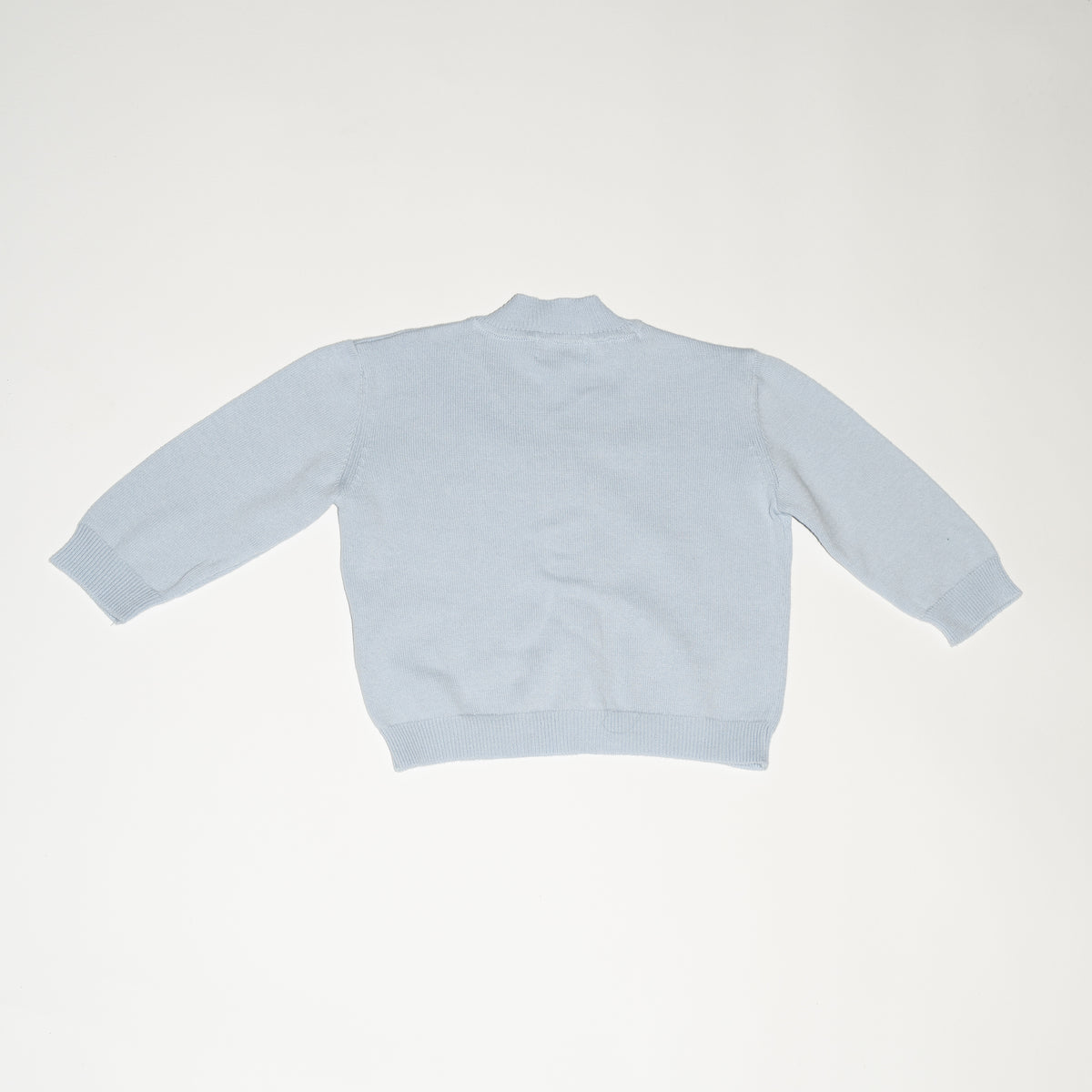 de achterkant van de besito baby cardigan in baby blue skies van merino wol