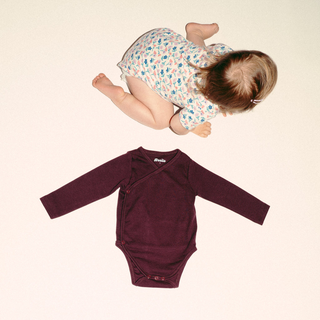 een foto van de wrap bodysuit overslagromper in chocolate bordeaux van besito baby