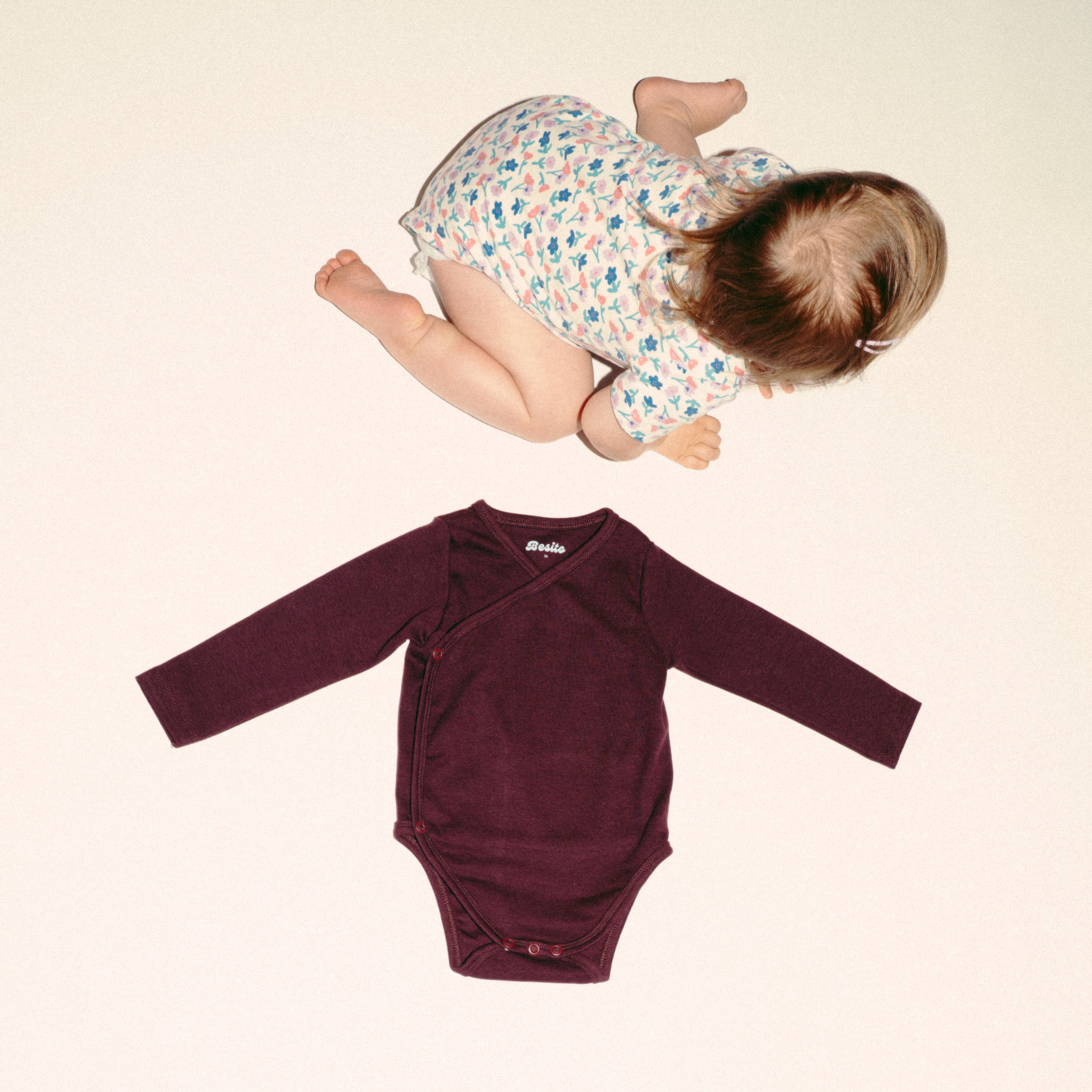 een foto van de wrap bodysuit overslagromper in chocolate bordeaux van besito baby