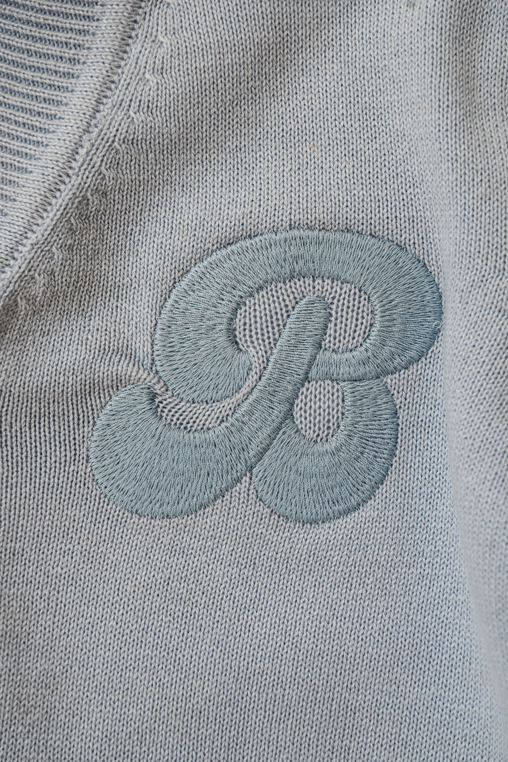 een detailfoto van het embroidery van besito baby op het merino wollen vestje