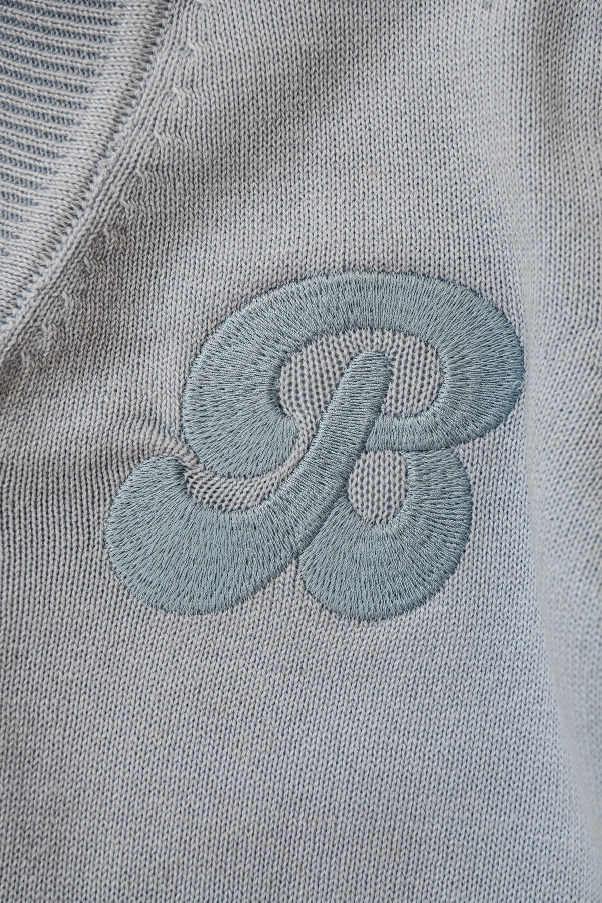 een detailfoto van het embroidery van besito baby op het merino wollen vestje