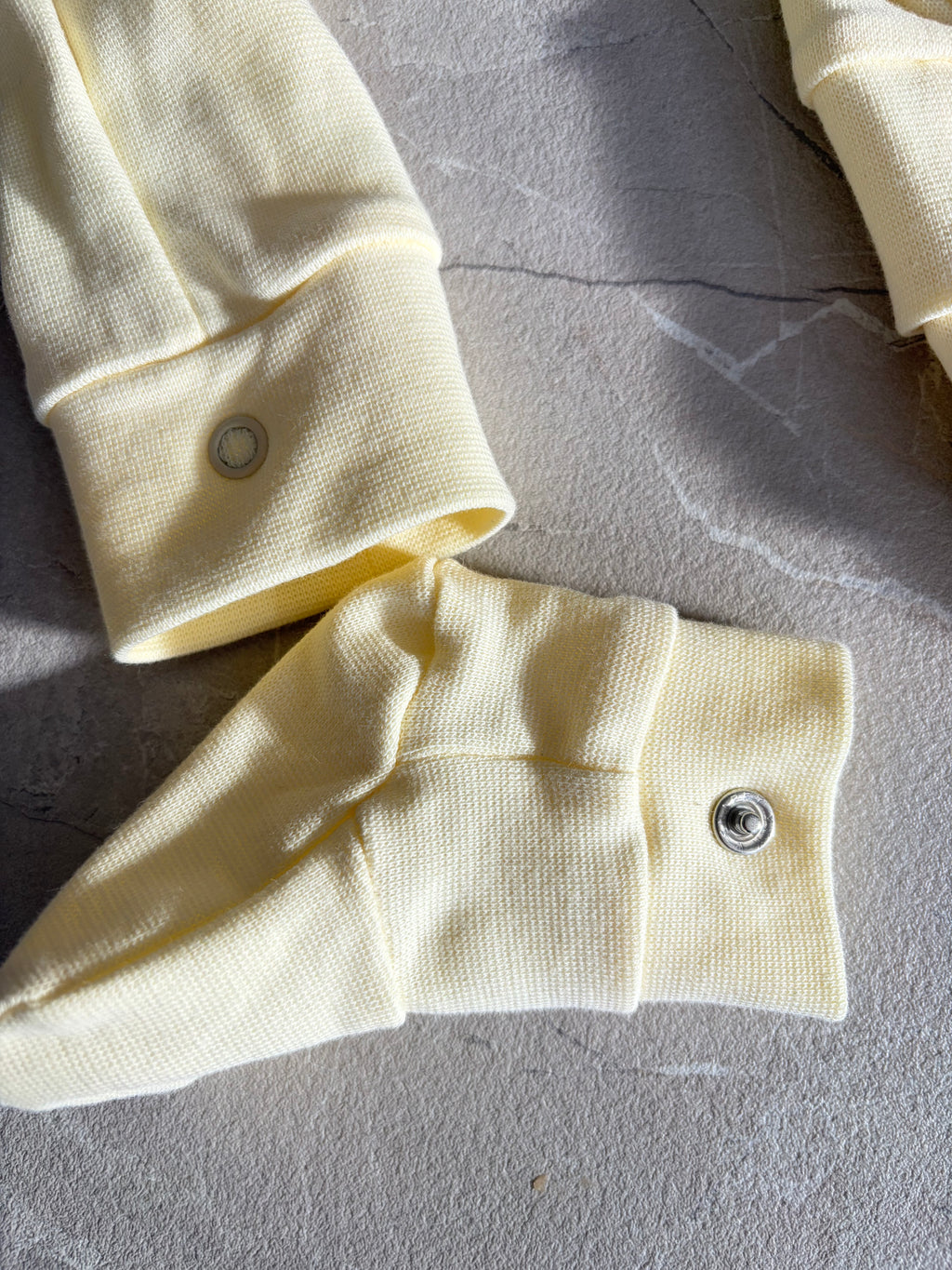 een detailfoto van de legging met afneembare sokjes in een botergele kleur van Besito Baby