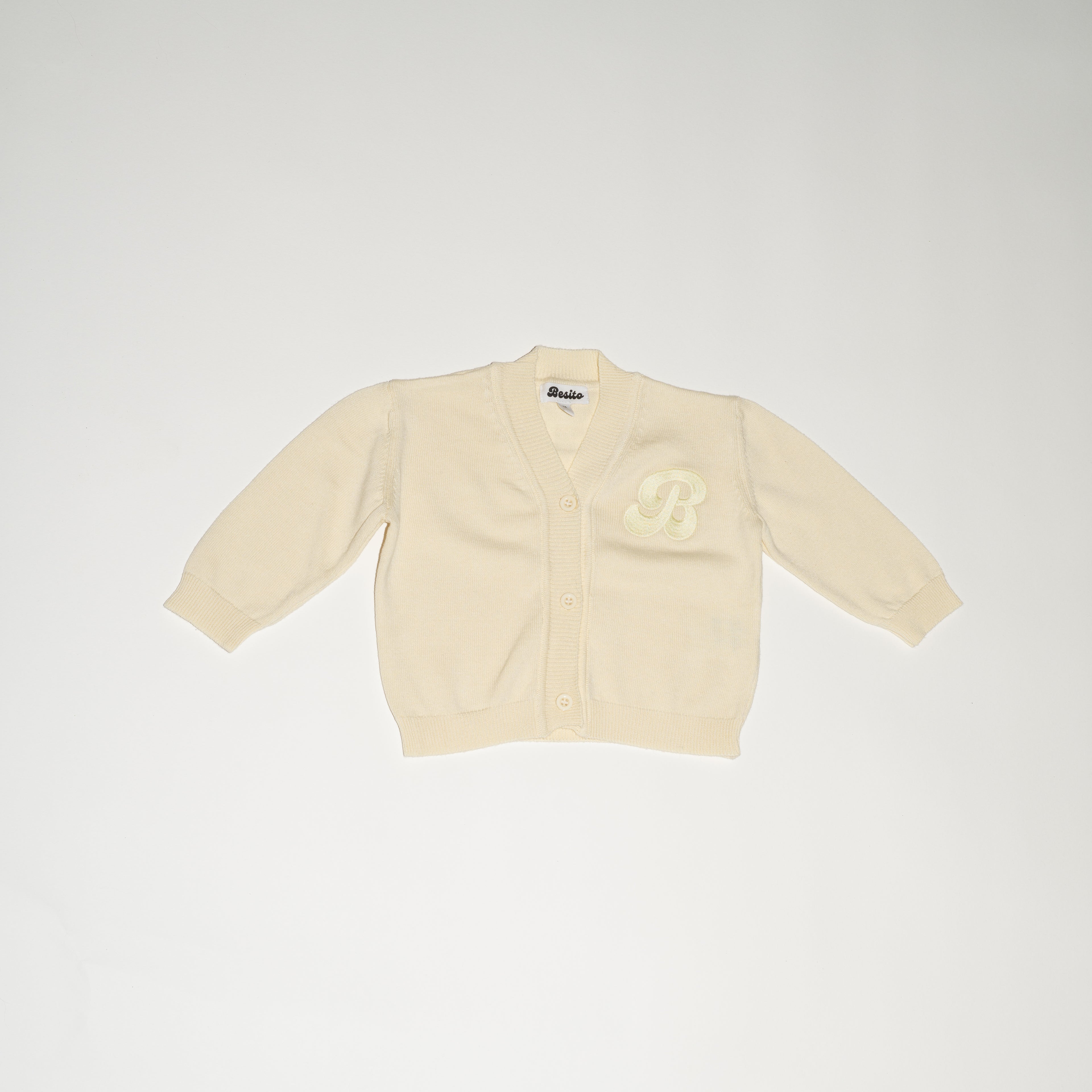 de voorkant van de perfect cardigan in butter yellow van merino wol van besito baby