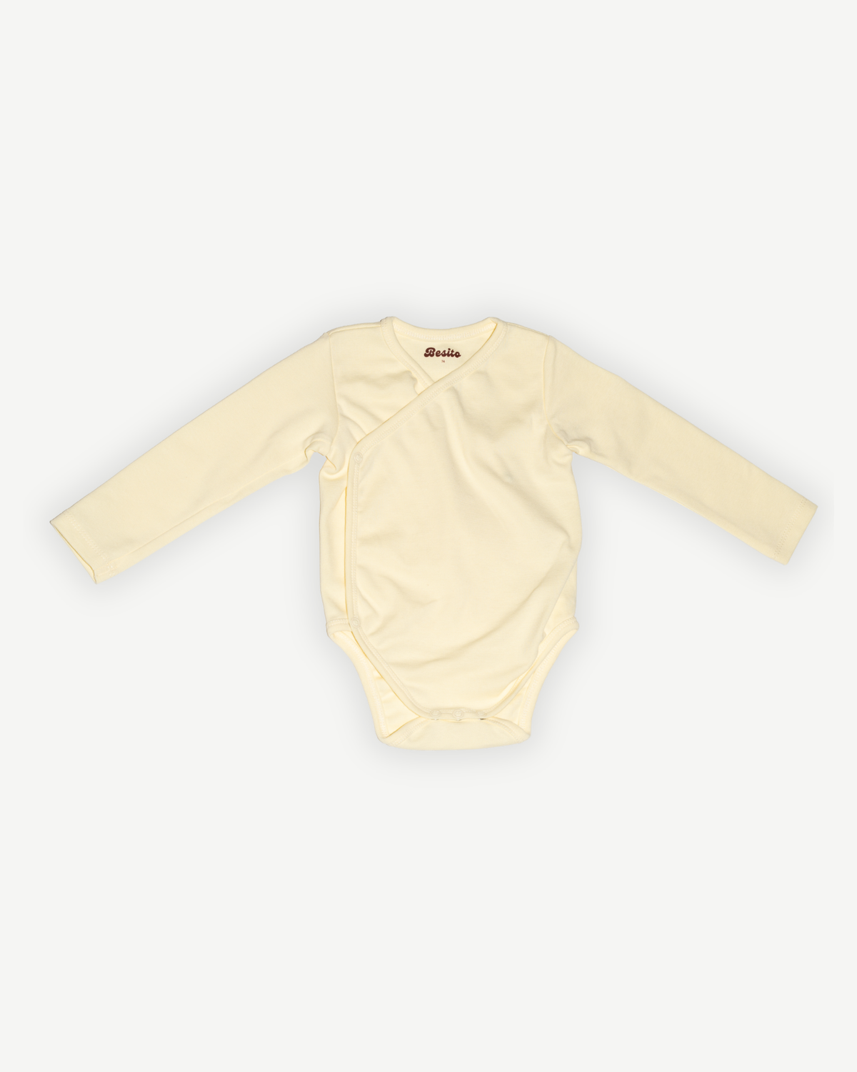 de voorkant van de romper van besito baby in butter yellow