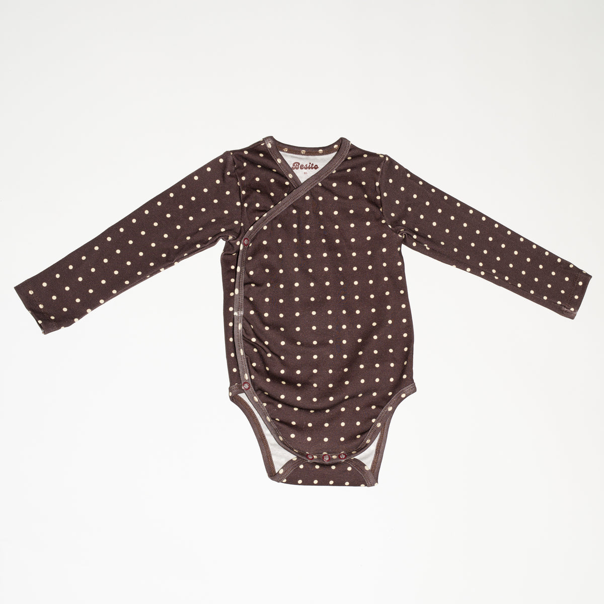de voorkant van de polkadot wrap bodysuit van besito baby 
